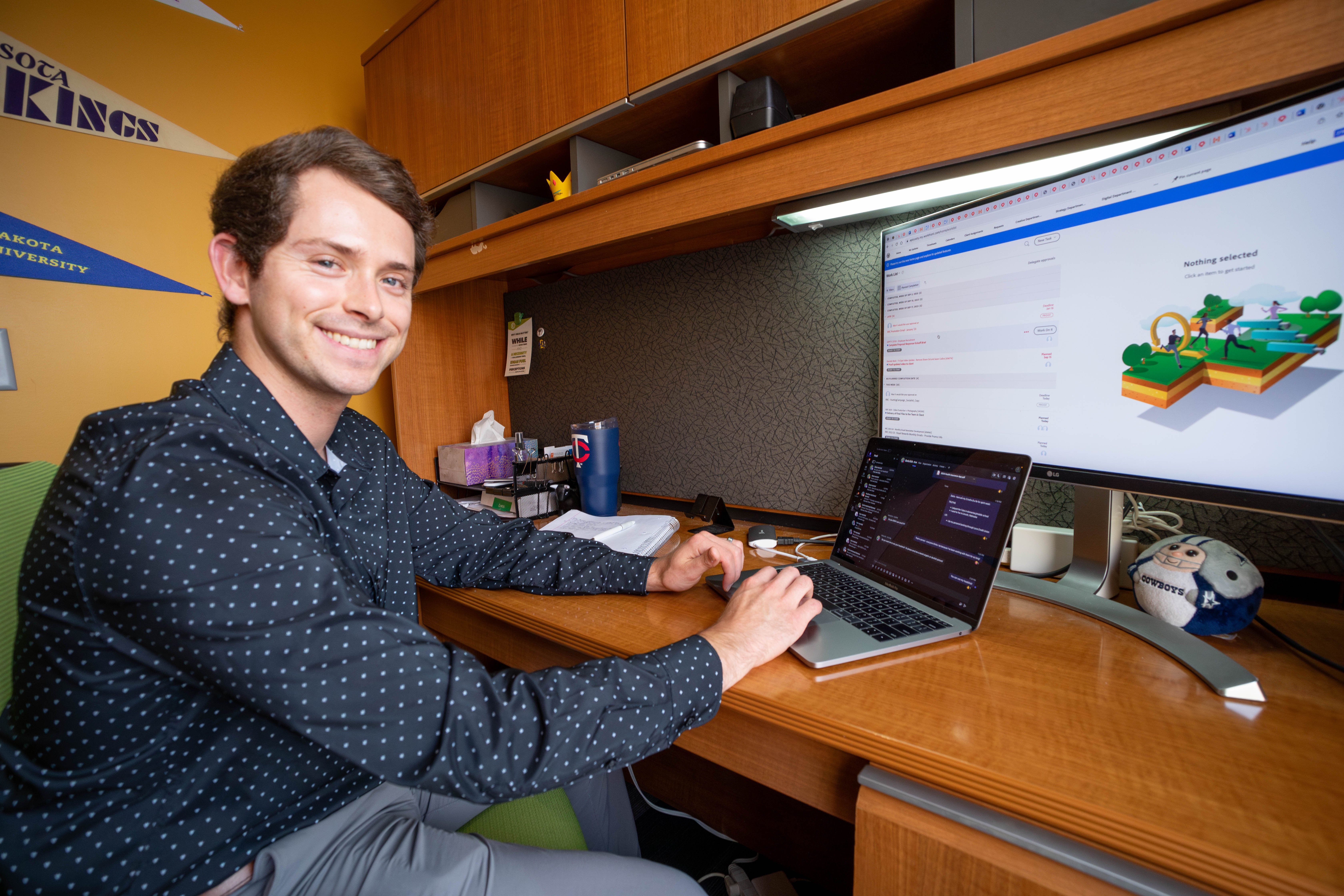 Account executive, Seth Bjordal, smiling at his desk